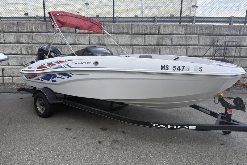 Tahoe T18 2022 Tahoe T18 boat on trailer with red canopy, parked on concrete surface.