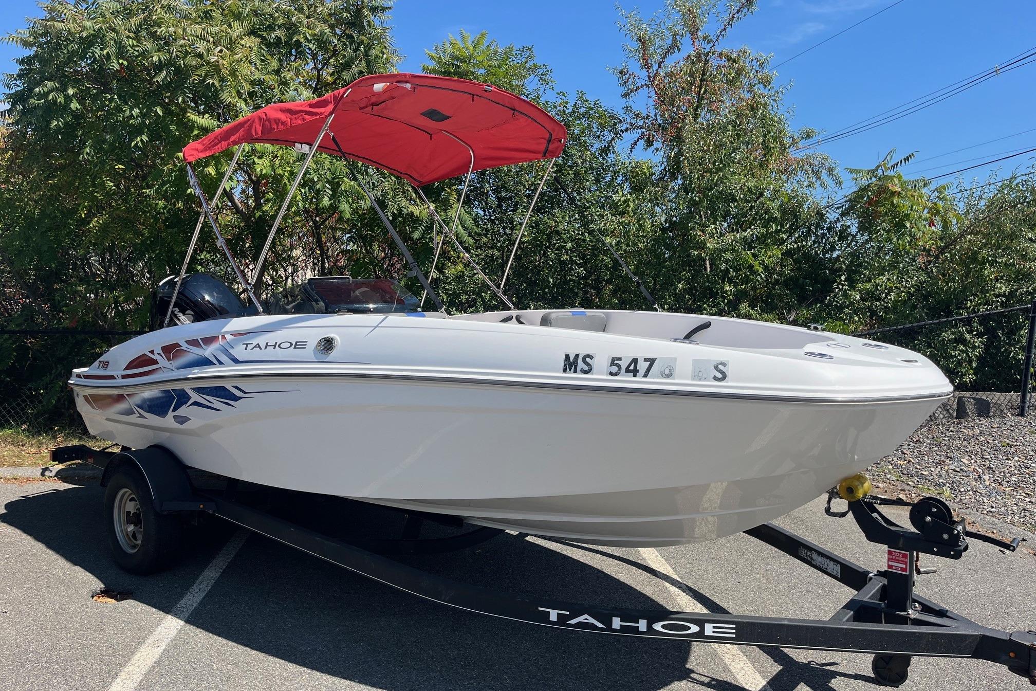 Tahoe T18 2022 Tahoe T18 boat with red canopy on trailer, parked outdoors.