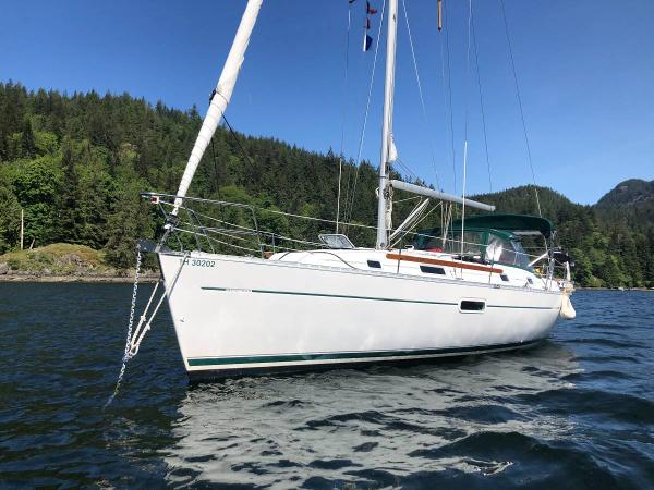 Beneteau 361 2003 Beneteau 361 sailboat on calm water, surrounded by lush green forest.