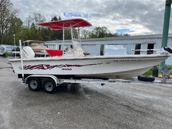 Rhino 2200 Bay Boss 2004 Rhino 2200 BAY BOSS boat on trailer, red accents, parked outdoors.