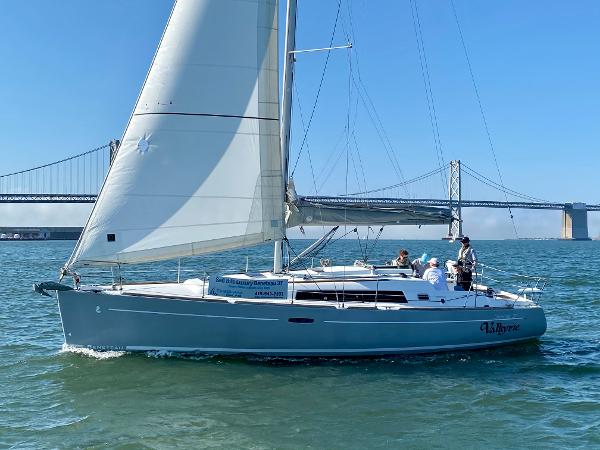 Beneteau 37 2013 Beneteau 37 sailboat cruising near a bridge on a sunny day.