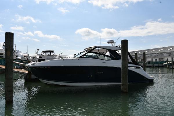 Sea Ray 320 Sundancer 2023 Sea Ray Sundancer 320 yacht docked in a marina under a clear blue sky.