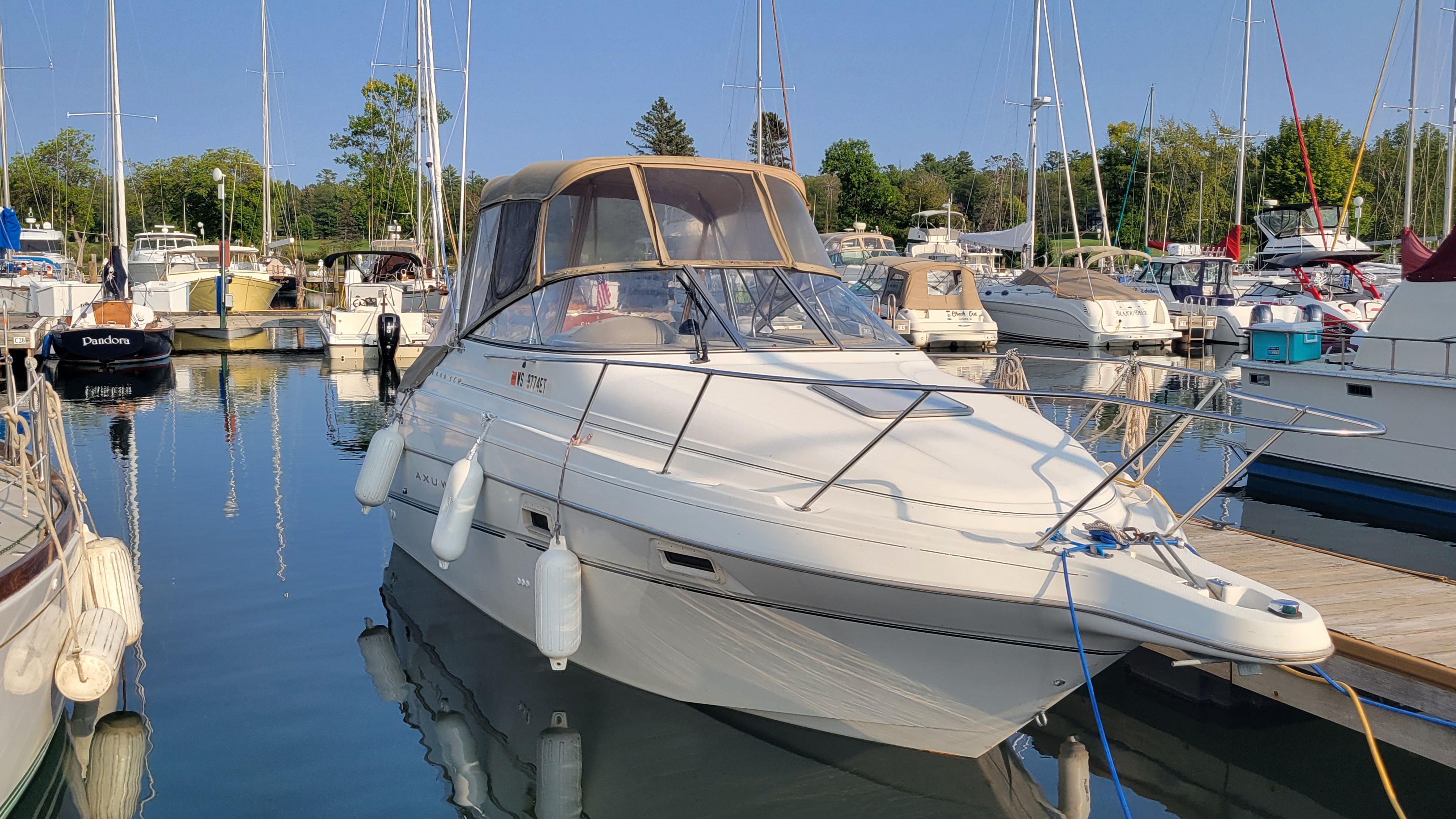 Maxum 2400 SCR 2000 Maxum 2400 SCR boat docked in a marina, surrounded by other vessels.