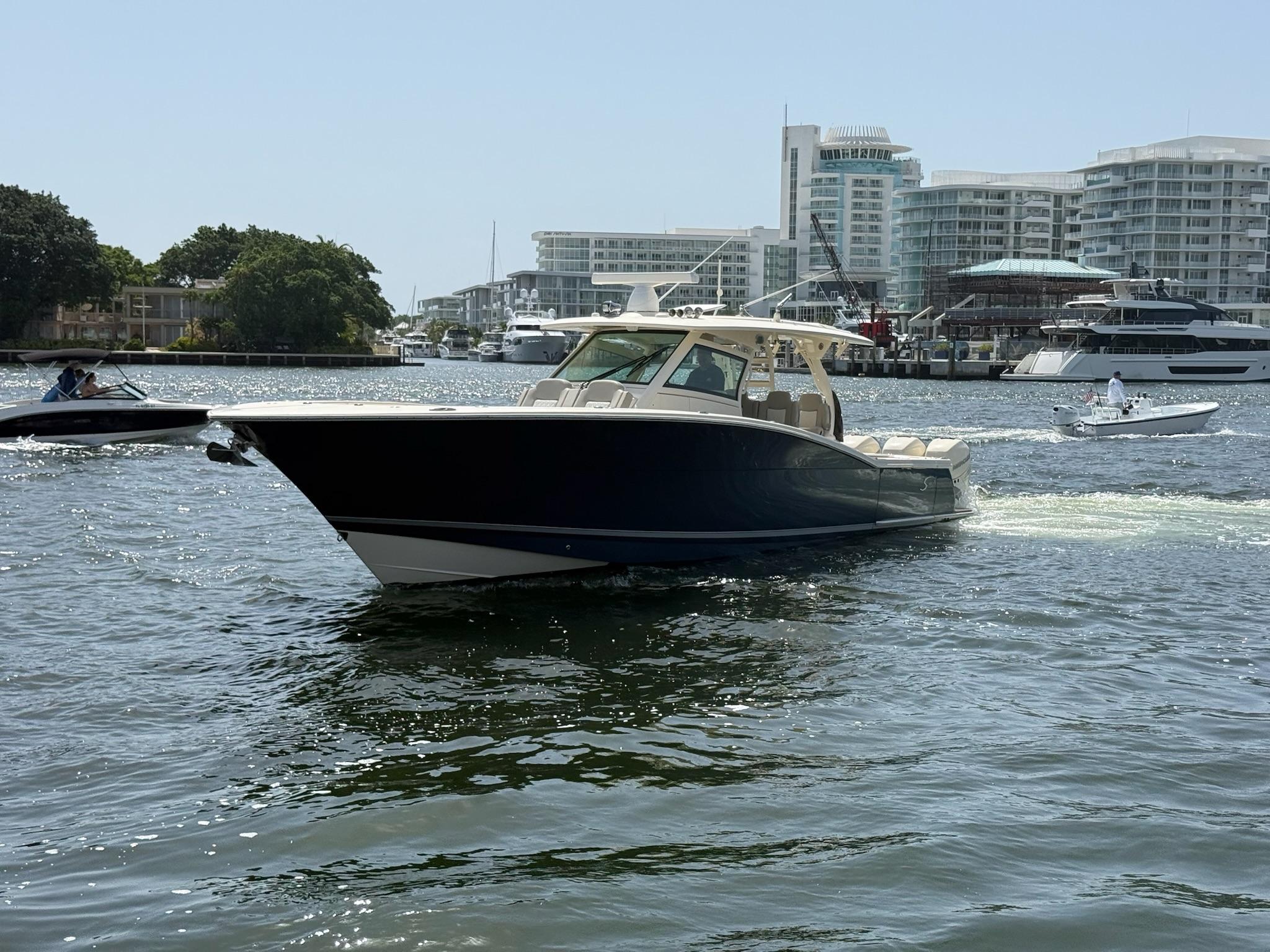 Scout 420 Lxf 2019 Scout 420 LXF boat cruising in a marina with modern buildings in the background.