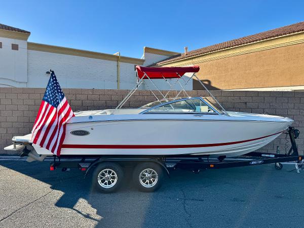 Cobalt 220S 2017 Cobalt 220S boat on trailer with American flag, parked outdoors.
