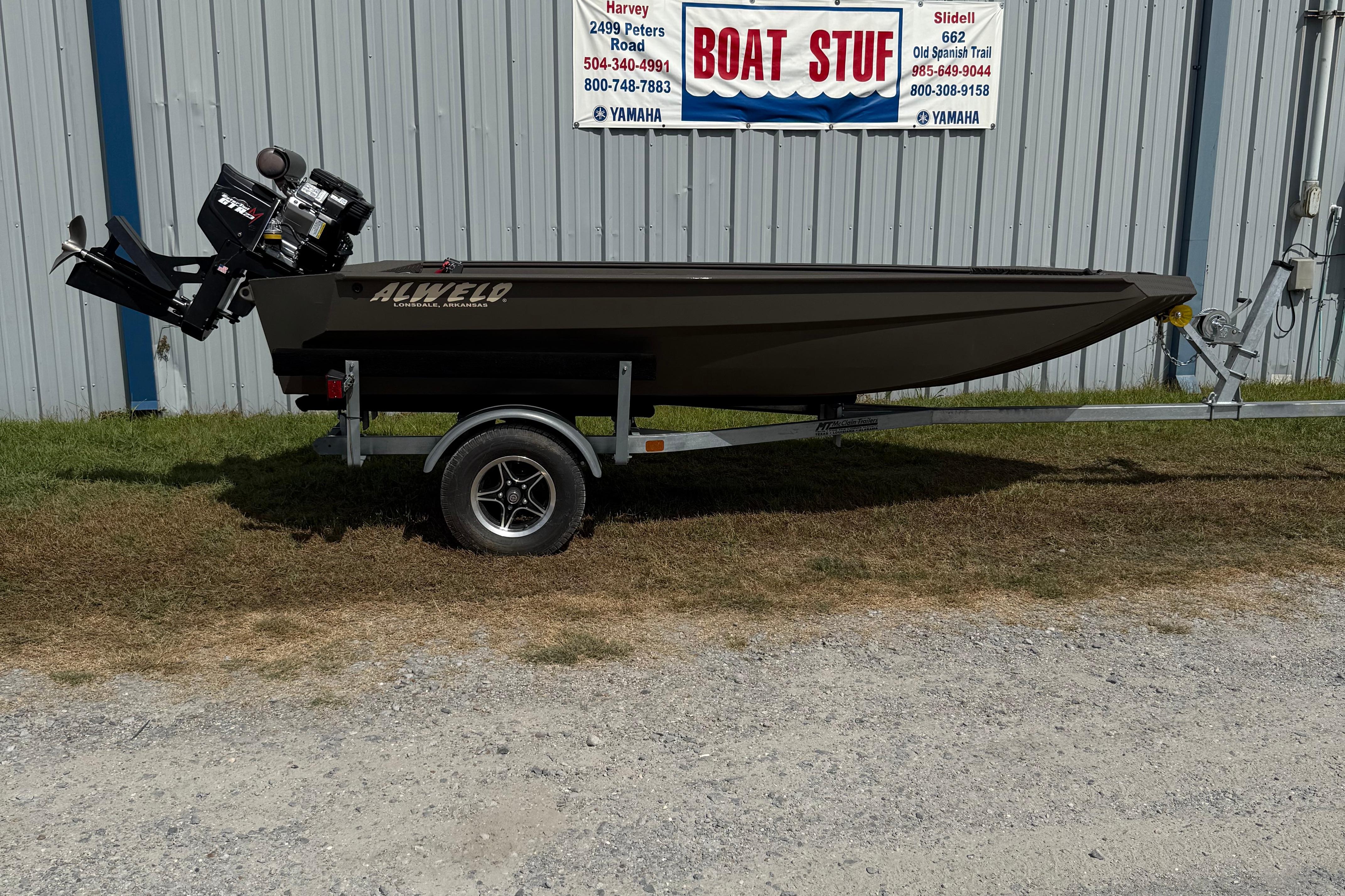 Alweld 1548 Invader 2025 Alweld 1548 Invader boat on trailer, parked outside a metal building.