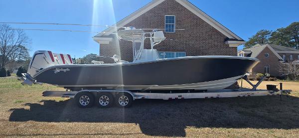 Yellowfin 36 2017 Yellowfin 36 boat on trailer, parked in front of a brick house.