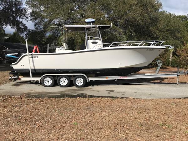 Mako 284 CC 2005 Mako 284 CC boat on a triple-axle trailer, parked outdoors.