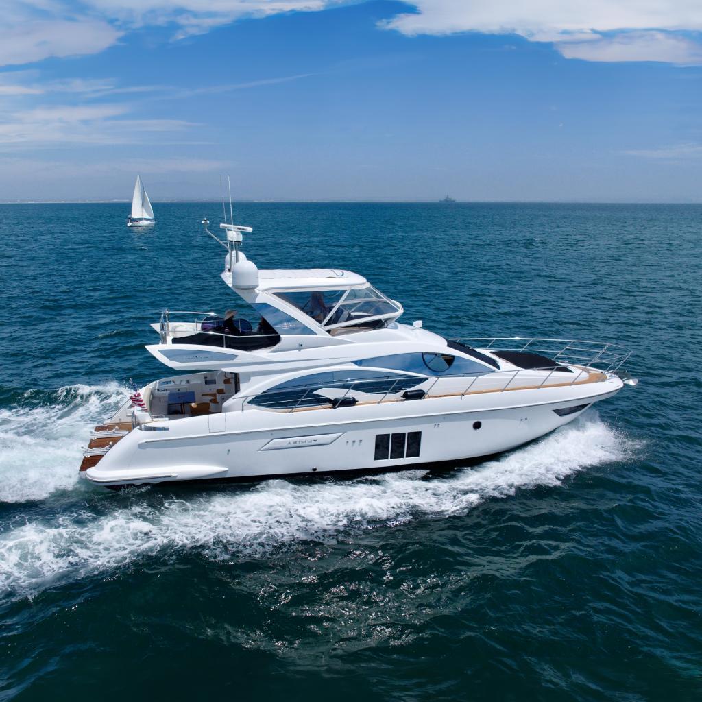 Azimut 54 Fly 2015 Azimut 54 Fly yacht cruising on open sea with sailboat in background.