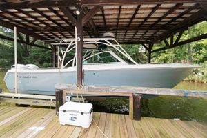 Sailfish 325 DC 2020 Sailfish 325 DC boat docked under wooden shelter, side view.