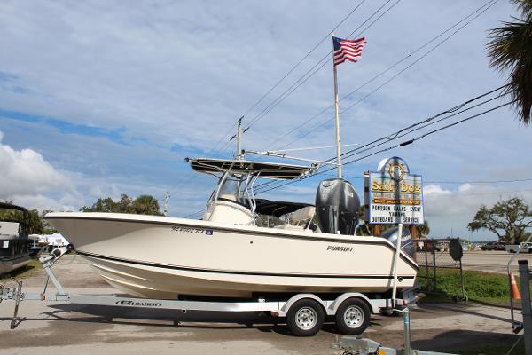 Pursuit C230 2008 Pursuit C230 boat on trailer, parked near a sign and American flag.