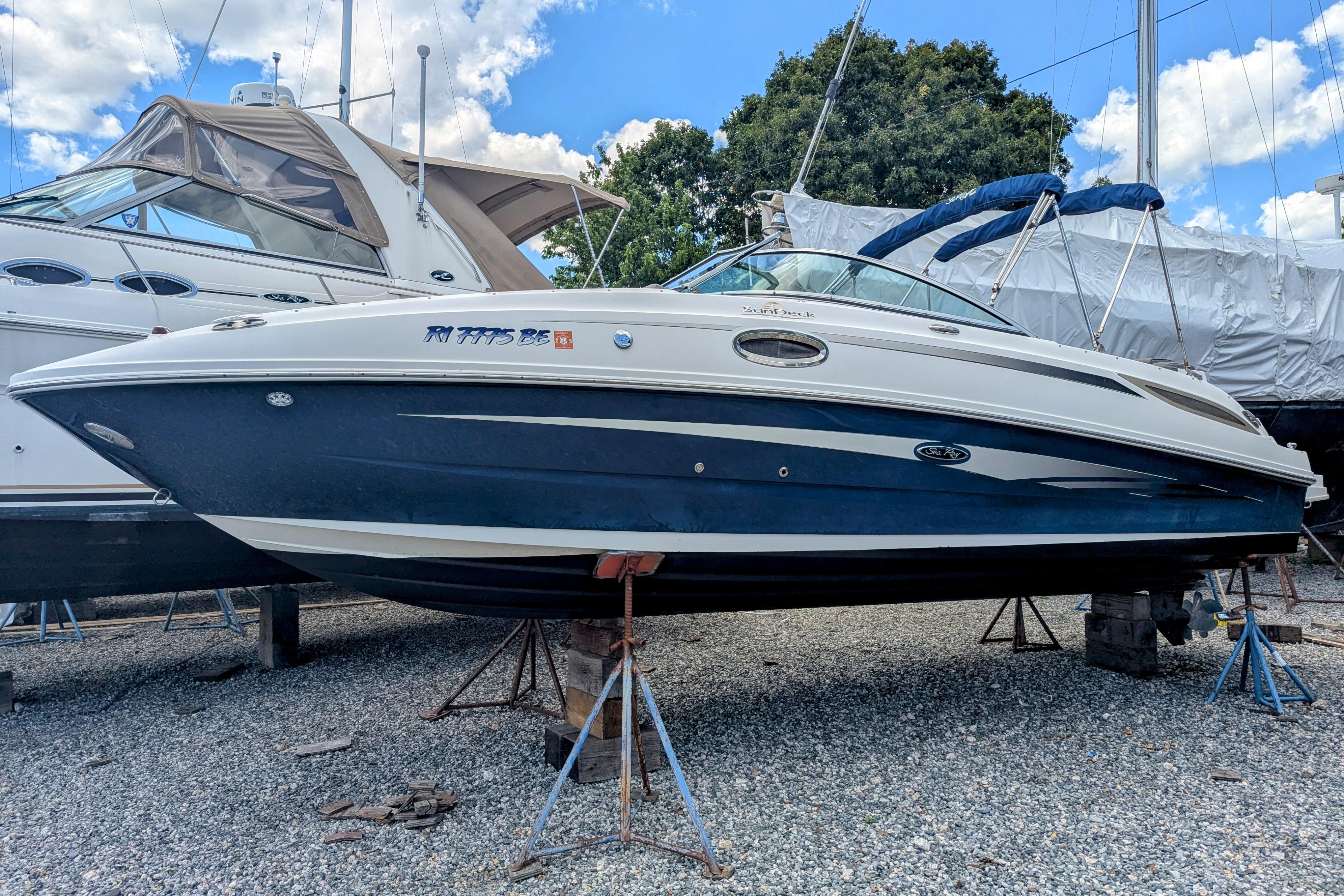 Sea Ray 260 Sundeck 2011 Sea Ray 260 Sundeck boat on stands, blue and white hull, outdoor storage.