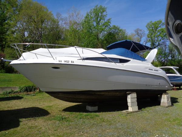 Bayliner 2855 Ciera 2002 Bayliner 2855 Ciera boat on blocks, outdoors, with blue canopy.