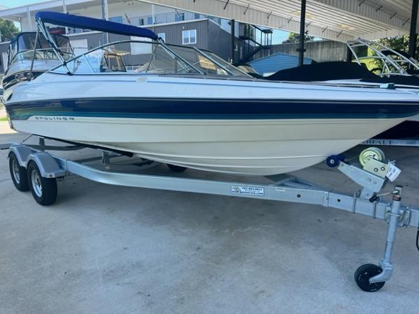 Bayliner 2050 Capri 1995 Bayliner 2050 Capri boat on trailer, under a covered area.