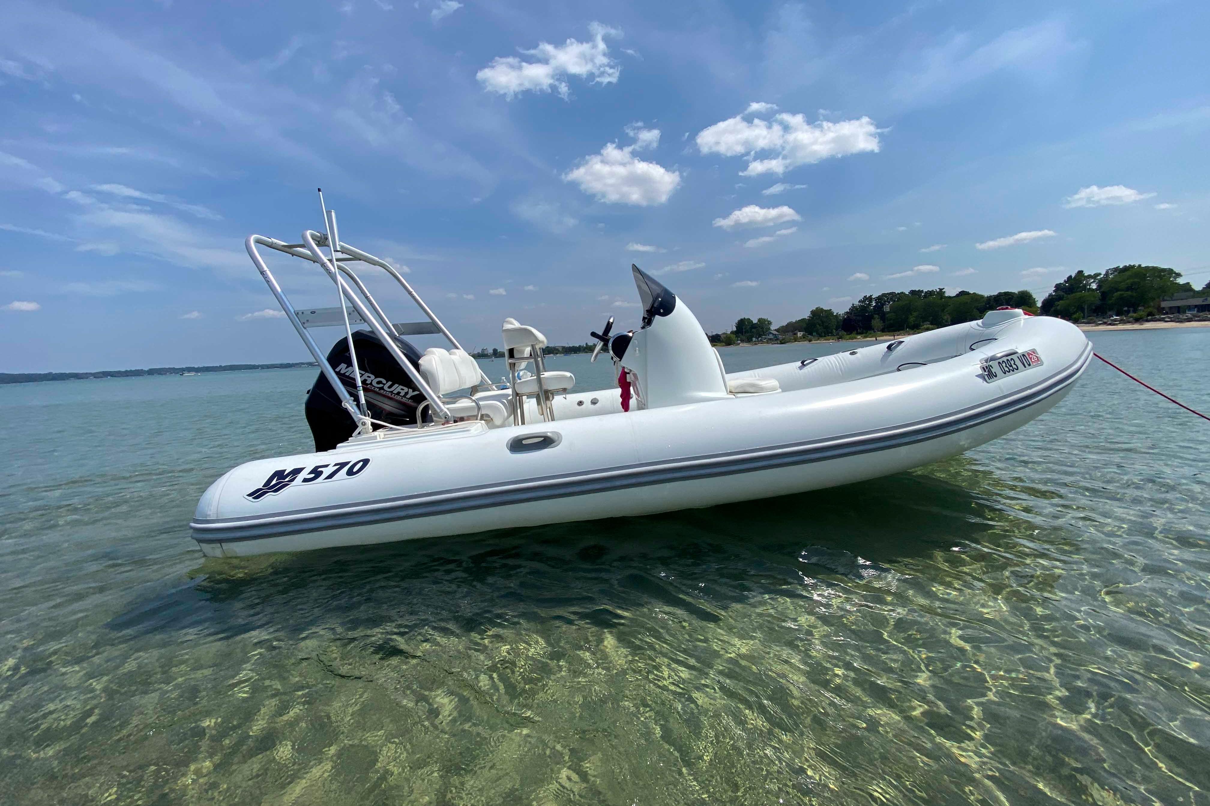 Mercury Inflatables M570 2013 Mercury Inflatables M570 boat floating on clear water under a blue sky.