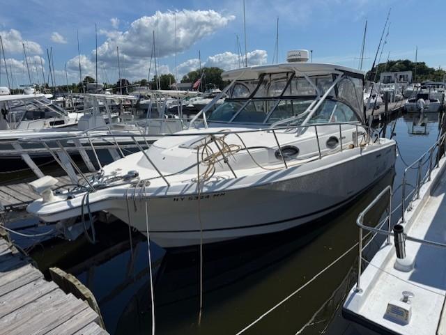 Wellcraft 290 Coastal 2015 Wellcraft 290 Coastal boat docked at marina under blue sky.