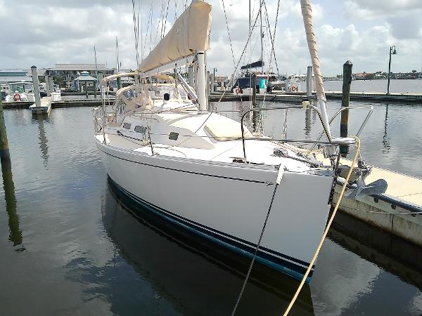 J Boats J/32 2004 J Boats J/32 sailboat docked in a marina, featuring sleek white hull and beige sail.