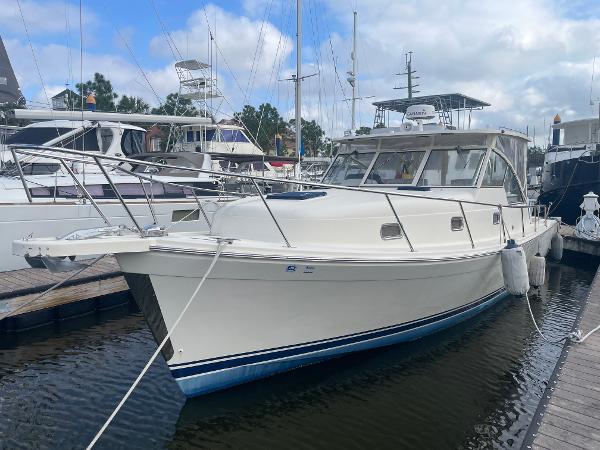 Mainship Pilot 34 2006 Mainship Pilot 34 docked at marina, featuring sleek design and white hull.