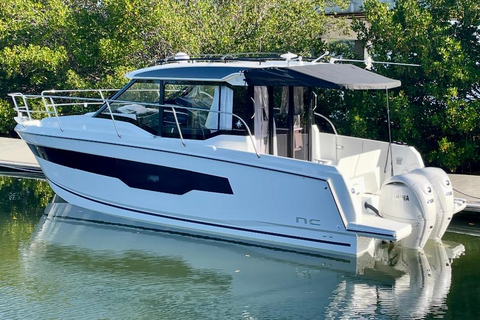 Jeanneau NC895 S2 2024 Jeanneau NC895 S2 boat with twin Yamaha engines, docked in a serene setting.
