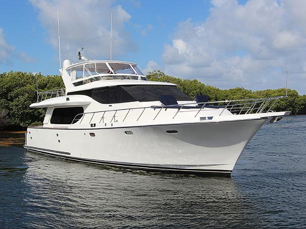 Symbol 62 Pilothouse 2001 Symbol 62 Pilothouse yacht on water, surrounded by lush greenery and blue sky.