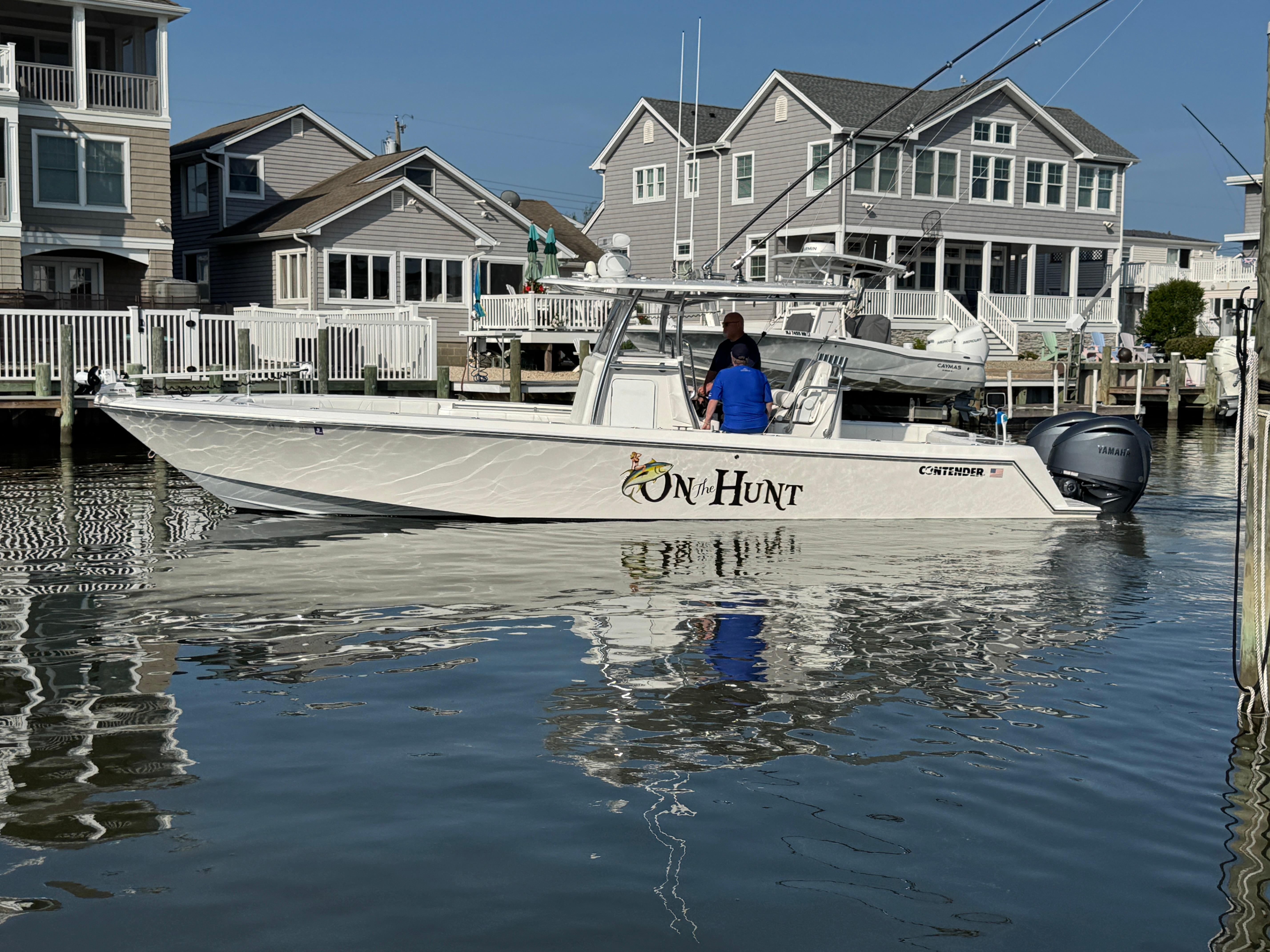 Contender 32 ST 2022 Contender 32 ST boat docked near waterfront homes, featuring Yamaha engines.