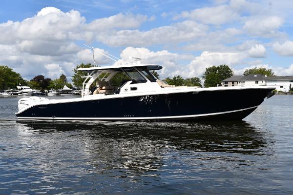 Pursuit S 408 Sport 2019 Pursuit S 408 Sport boat on calm water under a partly cloudy sky.