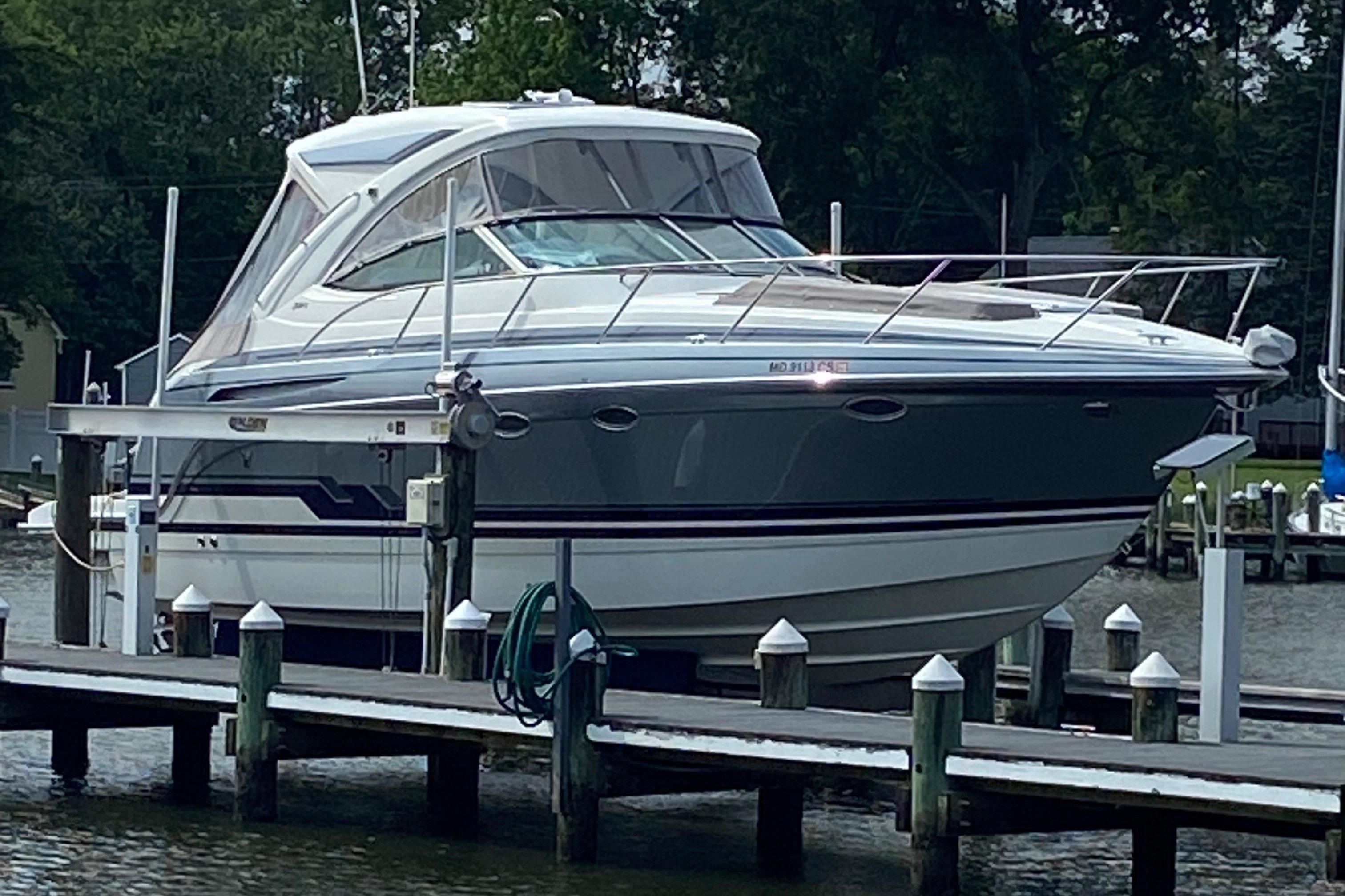 Formula 34 PC 2019 Formula 34 PC boat docked on a lift by the water.