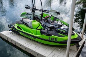 Sea-Doo RXT-X 300 2020 Sea-Doo RXT-X 300 jet ski in vibrant green, docked on a serene lake.