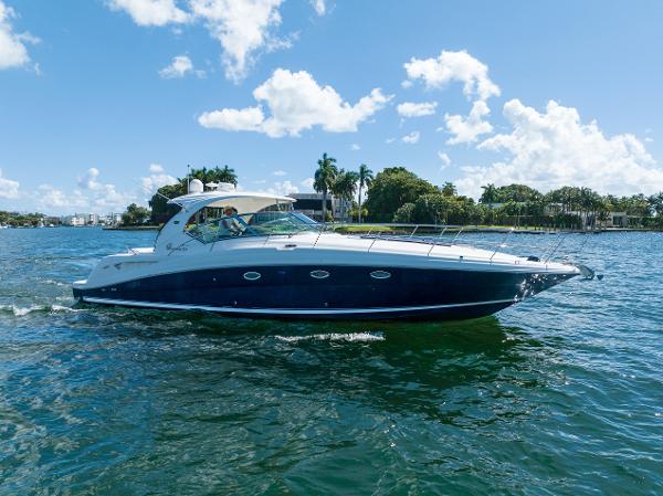 Sea Ray 420 Sundancer 2004 Sea Ray 420 Sundancer yacht cruising on a sunny day, surrounded by lush greenery.
