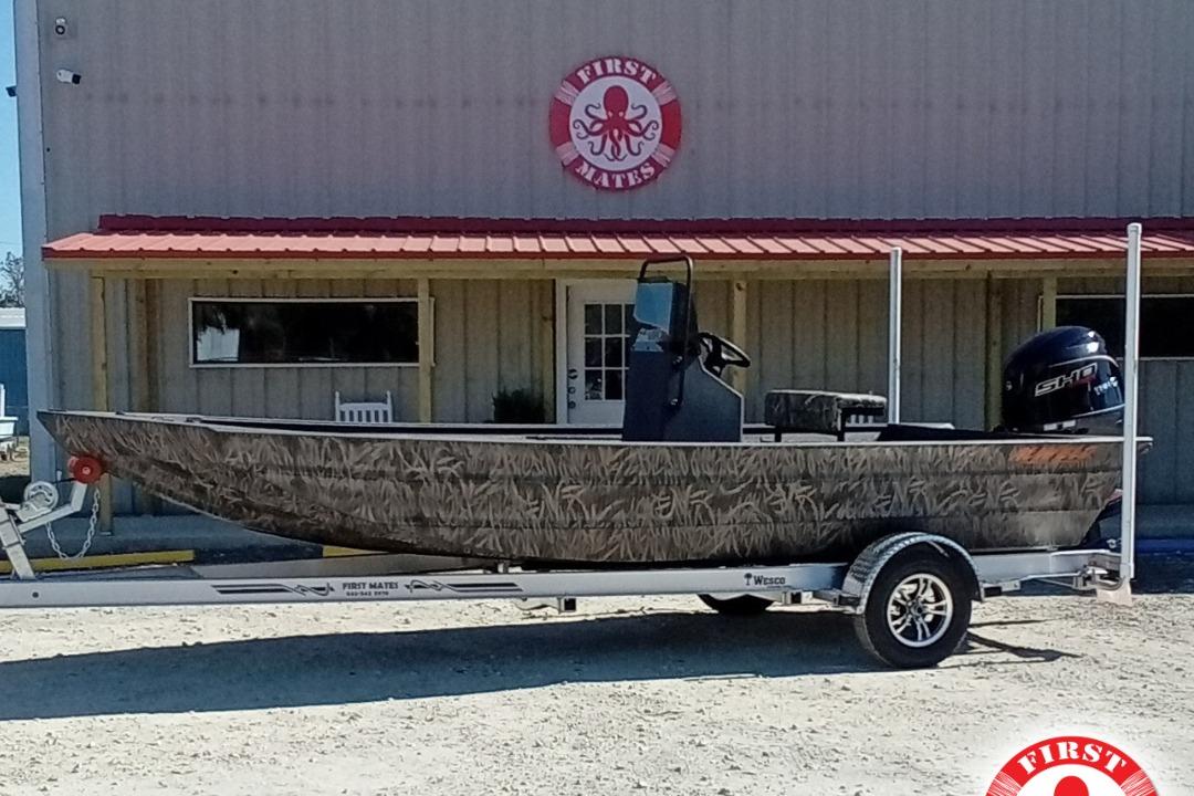 Alweld 1960VVCC Bay 2025 Alweld 1960VVCC Bay boat on trailer, camo design, parked outside a building.