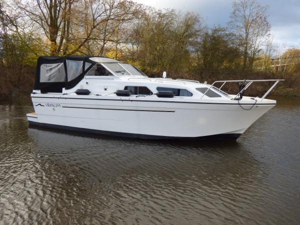 Viking 295 Highline 2018 Viking 295 Highline boat on a calm river with trees in the background.