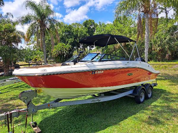 Sea Ray SPX 230 Outboard 2019 Sea Ray SPX 230 OB boat on a trailer with palm trees in the background.