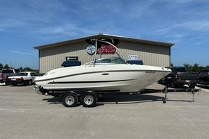 Sea Ray 210 SLX 2011 Sea Ray 210 SLX boat on trailer, parked outside a building under clear blue sky.