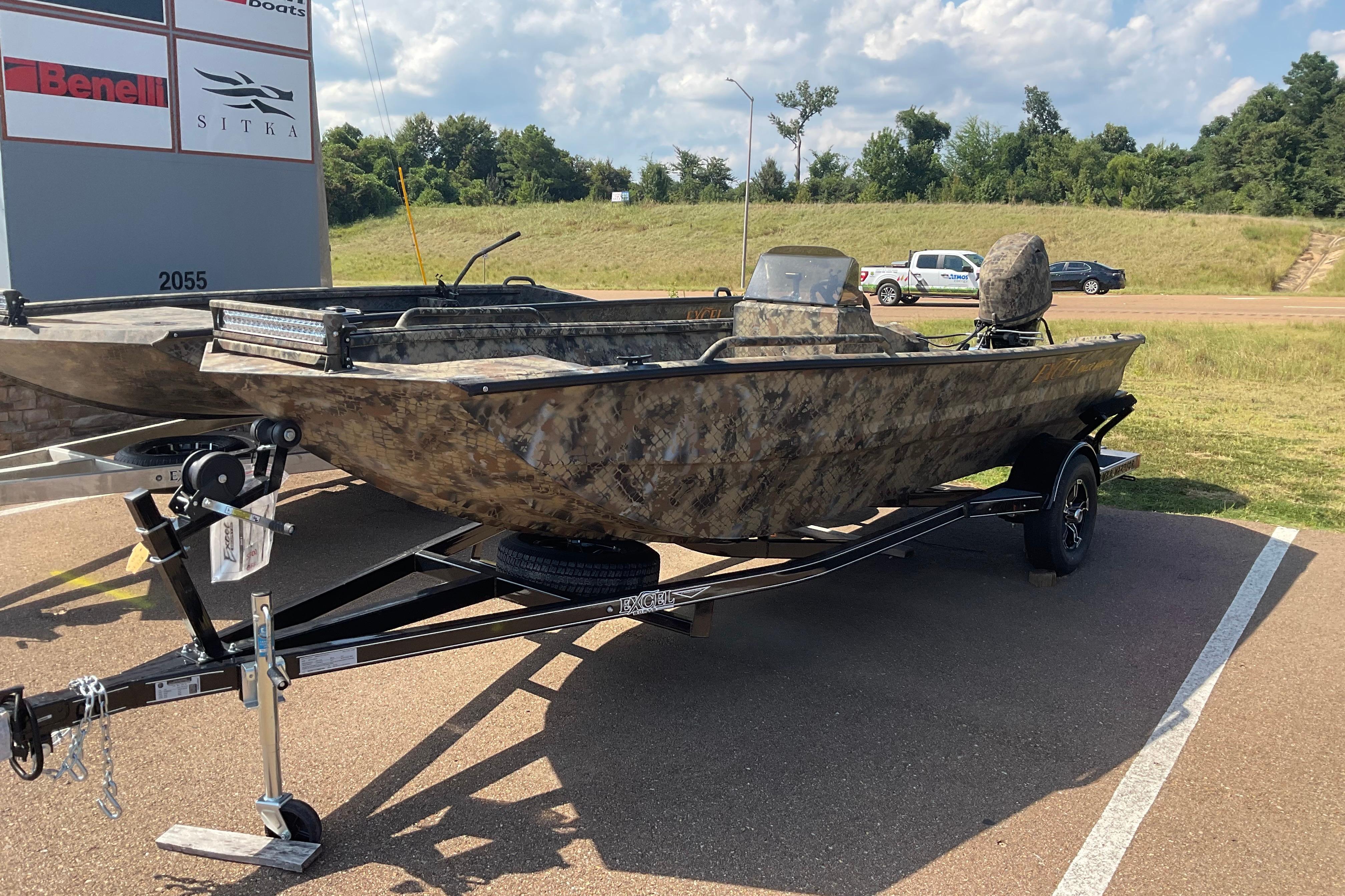 Excel 1751 River Warrior 2025 Excel 1751 River Warrior boat on trailer, camo design, parked outdoors.