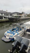 MasterCraft X23 2017 MasterCraft X23 boat docked in a canal with luxury homes in the background.