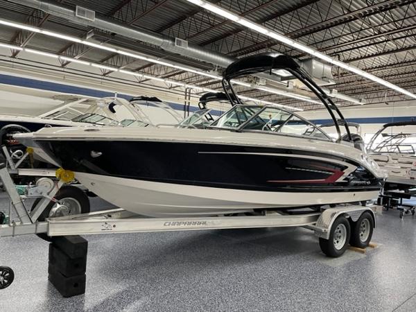Chaparral 21 SSi OB 2025 Chaparral 21 SSi OB boat on trailer in showroom, sleek design, black and white exterior.