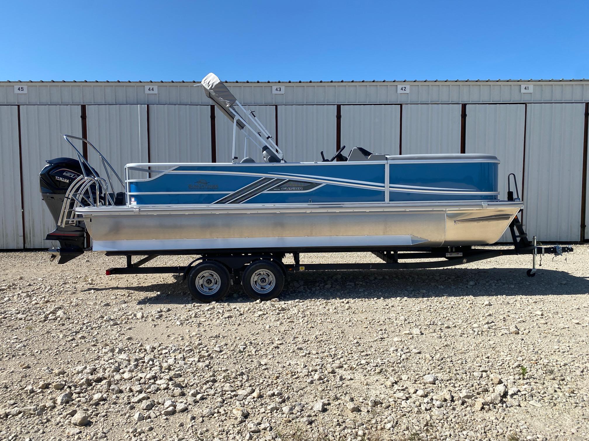 SunCatcher Fusion 324SL 2025 SunCatcher Fusion 324SL pontoon boat on trailer, parked outdoors.