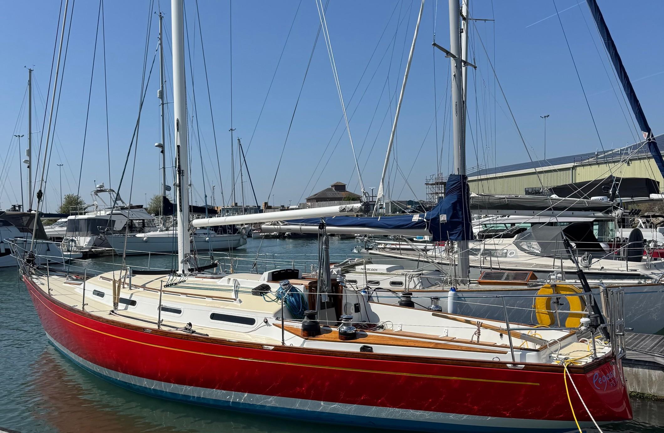 Wauquiez CHANCE 37 Red 1973 Wauquiez CHANCE 37 sailboat docked in a marina under clear blue skies.