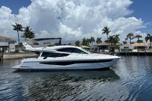 Galeon 550 Flybridge 2018 Galeon 550 Flybridge yacht on calm water, with palm trees and houses in the background.