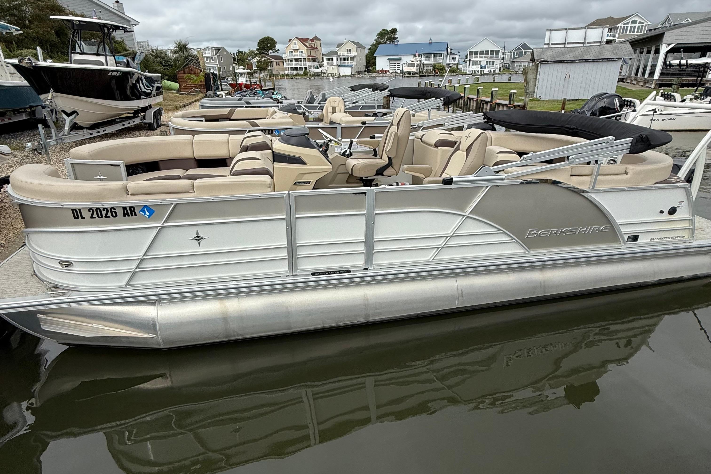 Berkshire 23RFX STS 2.75 2026 Berkshire 23RFX STS 2.75 pontoon boat docked, featuring beige seating and sleek design.