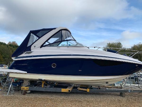 Regal 28 Express 2016 Regal 28 Express boat on trailer, blue and white design, parked outdoors.