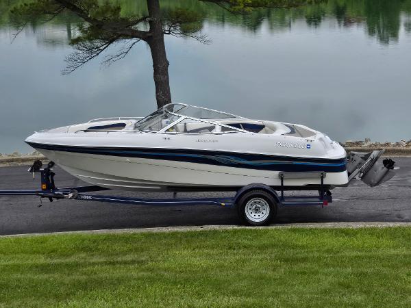 Four Winns Horizon RS RX 1998 Four Winns Horizon RS RX boat on trailer by a lake.