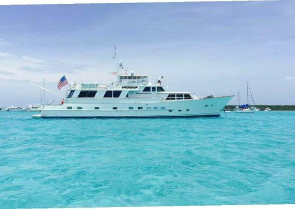 Burger Raised Pilothouse CPMY 1975 Burger Raised Pilothouse CPMY yacht on turquoise water, with American flag.