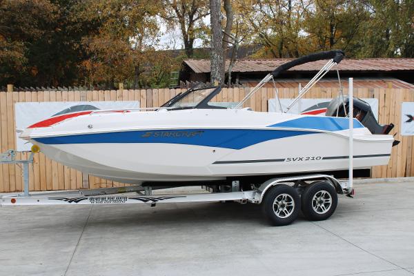 Starcraft SVX 210 OB DC 2024 Starcraft SVX 210 OB DC boat on trailer, featuring sleek design and vibrant colors.