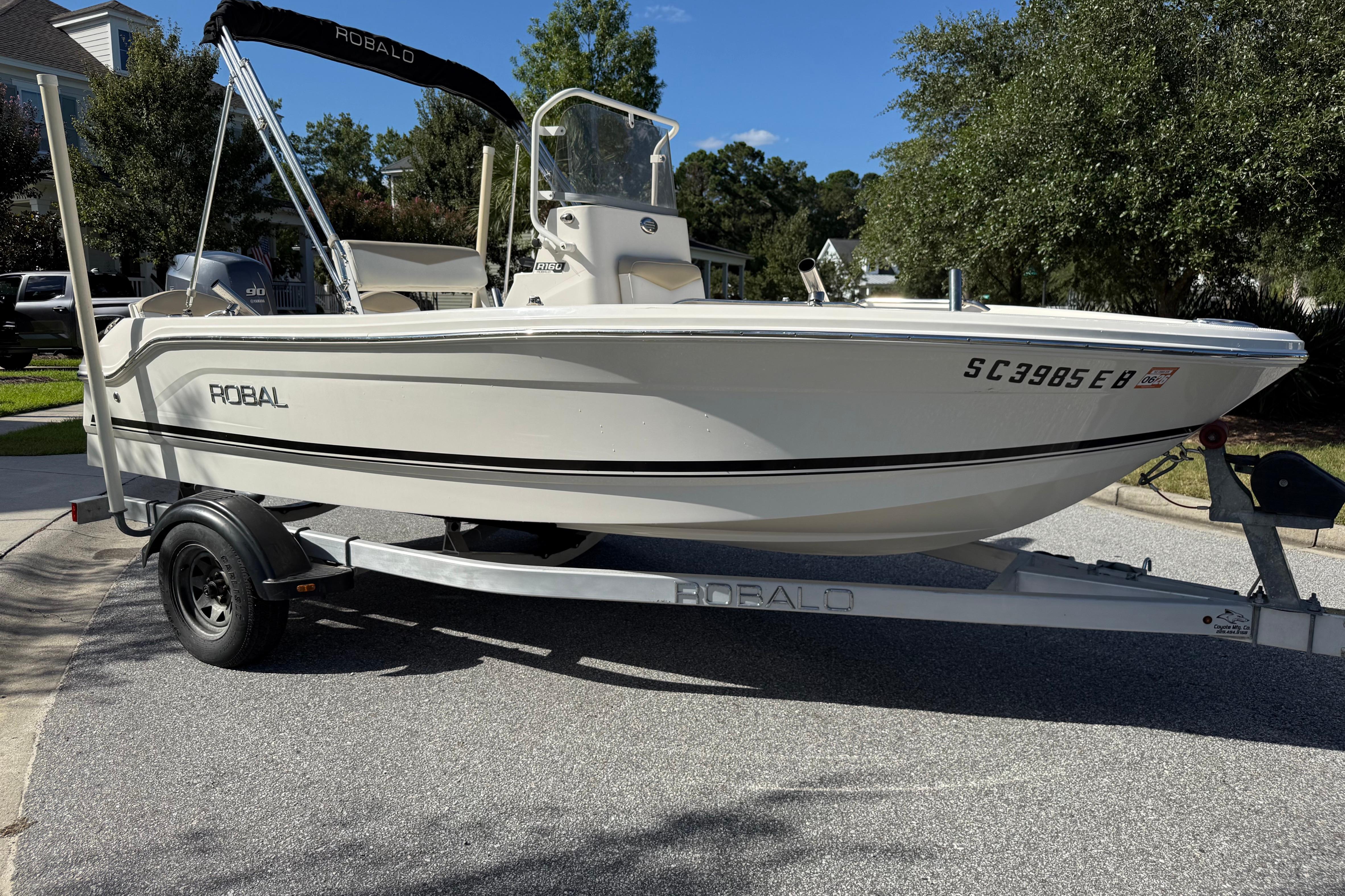 Robalo R160 Center Console 2016 Robalo R160 Center Console boat on trailer, parked in residential area.