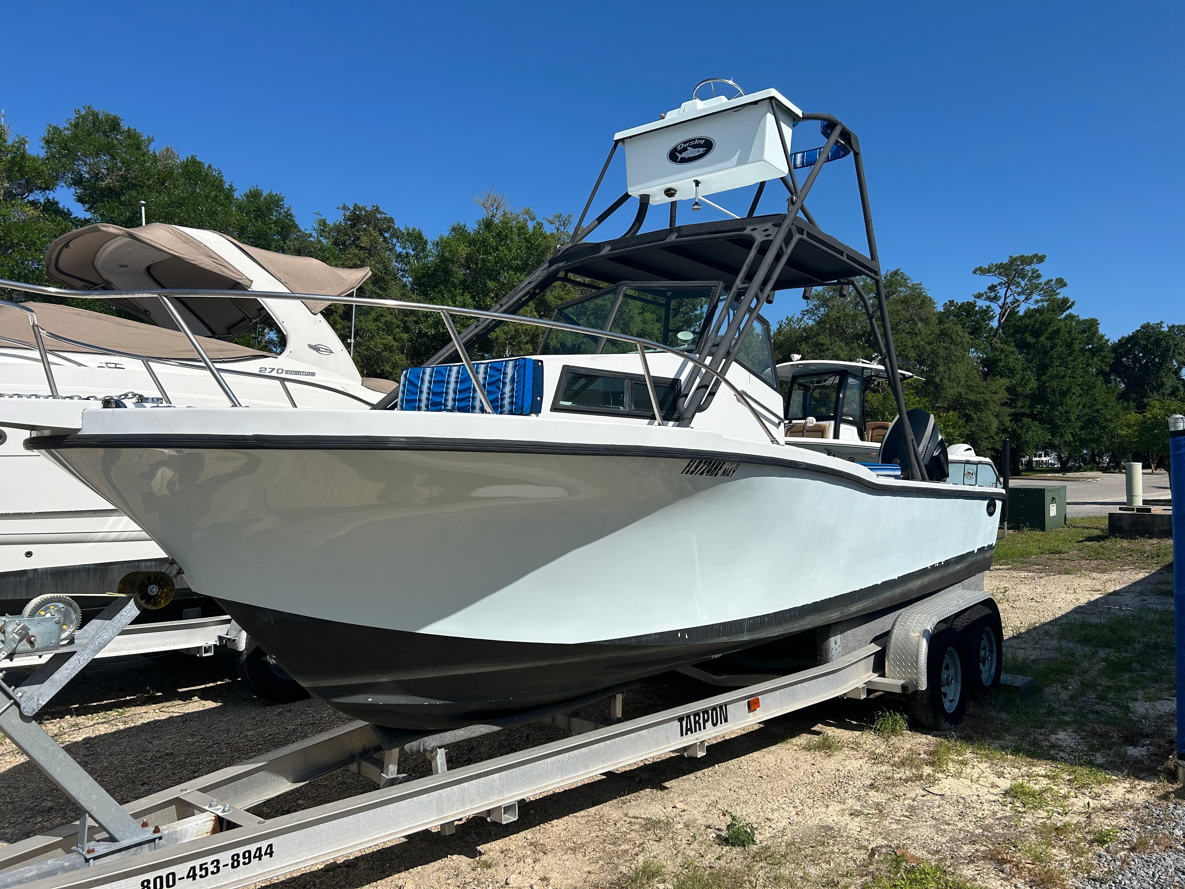 Dusky 256 1992 Dusky 256 boat on trailer, parked outdoors under clear blue sky.