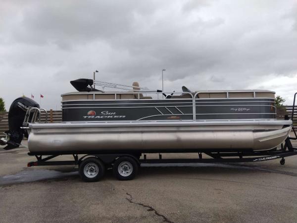 Sun Tracker Party Barge 22 RF DLX 2023 Sun Tracker Party Barge 22 RF DLX pontoon boat on trailer.