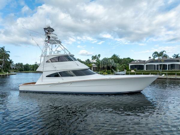 Viking 68 Enclosed Bridge Convertible 2021 Viking 68 Enclosed Bridge Convertible yacht on a serene waterway.