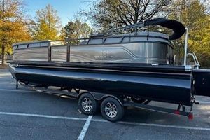 Regency 250 LE3 2024 Regency 250 LE3 pontoon boat on trailer in a scenic outdoor setting.