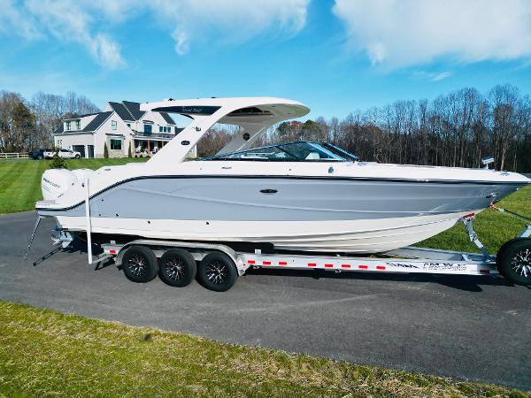 Sea Ray SLX 310 Outboard 2023 Sea Ray SLX 310 OB boat on trailer, parked in driveway near house.